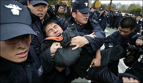 경찰이 가로등에 묶인 농민들을 연행하고 있다. 